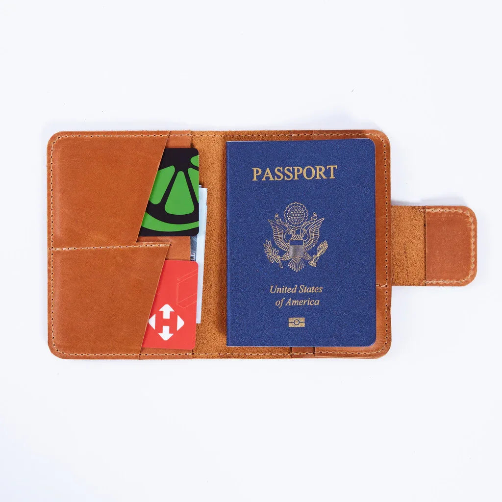 Open vintage leather passport cover showing passport sleeve, card slots and AirTag holder for organized travel